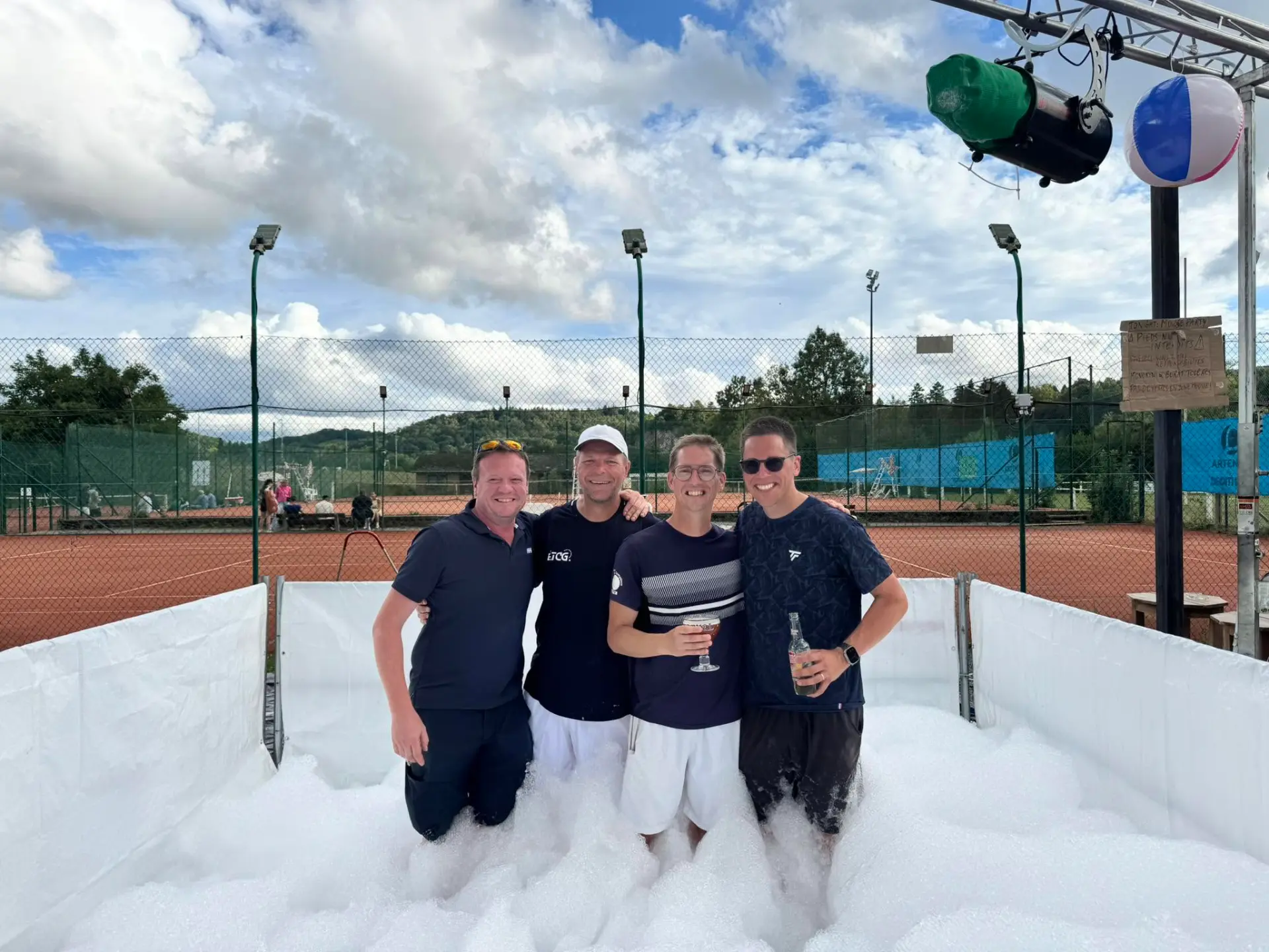 Quatre membres du TC Godinne profitent de l'ambiance festive sur les courts