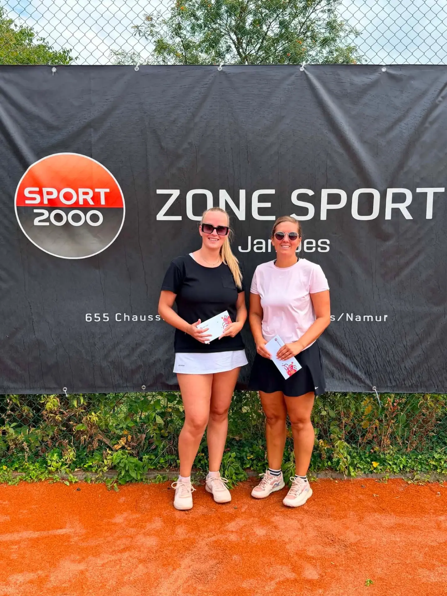 Vainqueure et finaliste dames posant devant la bâche Zone Sport Jambes
