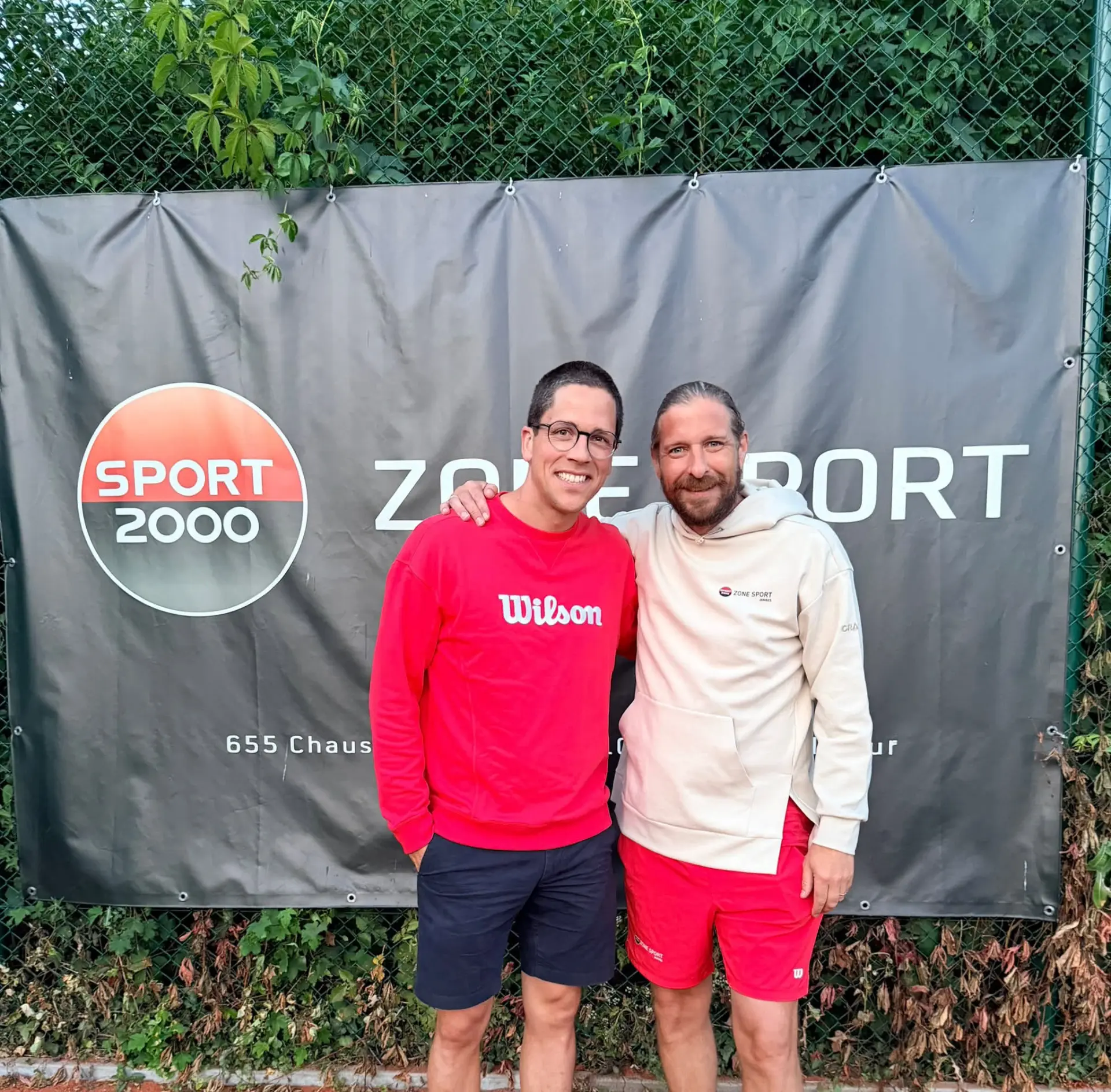 Le TC Godinne et Zone Sport Jambes devant la bâche du sponsor au bord des terrains